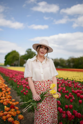 a lady in a white shirt  and a red floral printed skirt
